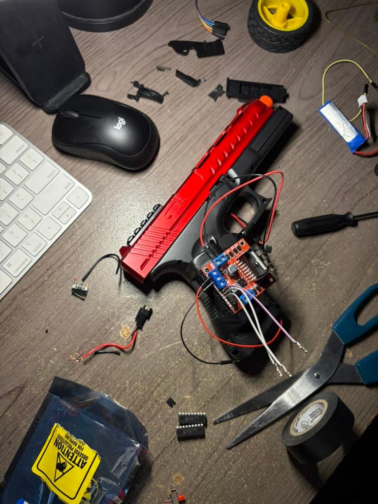 The red gel blaster wired to an L298N motor driver during assembly.