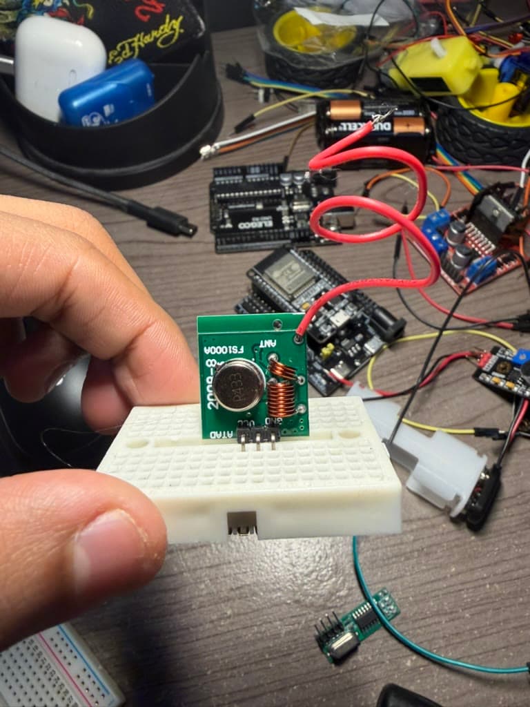 An FS1000A radio transmitter on a breadboard with ESP32 development boards behind it.