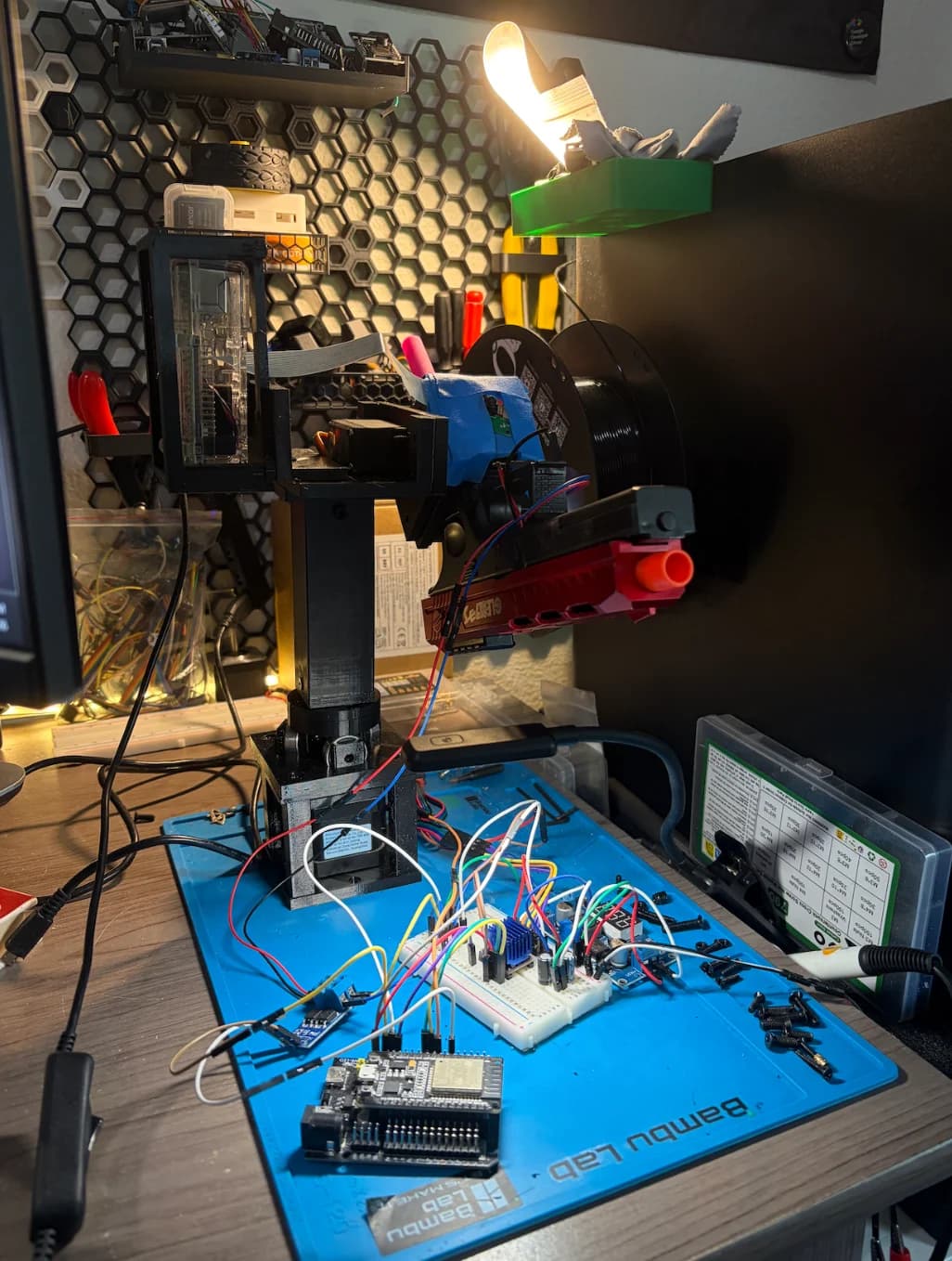 The completed autonomous alarm on my desk, with its camera, printed pan-and-tilt structure, toy blaster, and wired electronics.